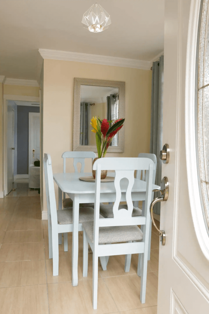 One Bedroom — dining area with light blue table and tropical flowers